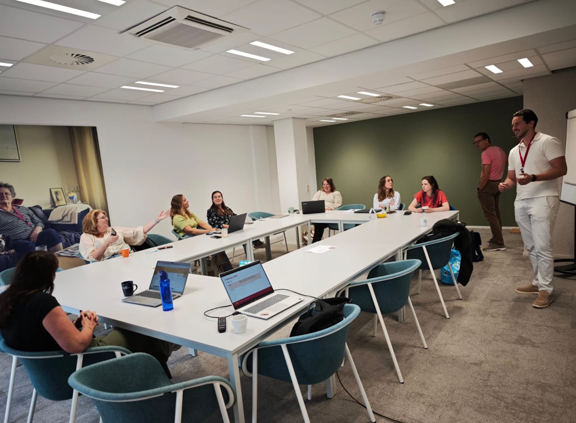Nick Wildeboer geeft een training aan een groep medewerkers rond een grote tafel